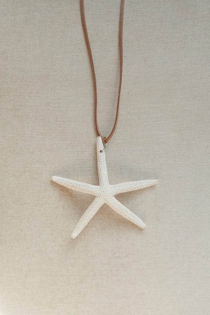 Starfish pendant necklace on a beige background