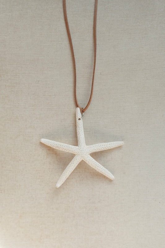 Starfish pendant necklace on a beige background