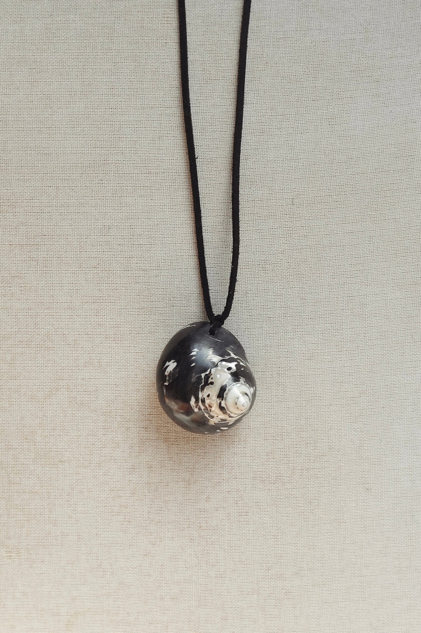 Necklace with a textured silver pendant on a light gray background