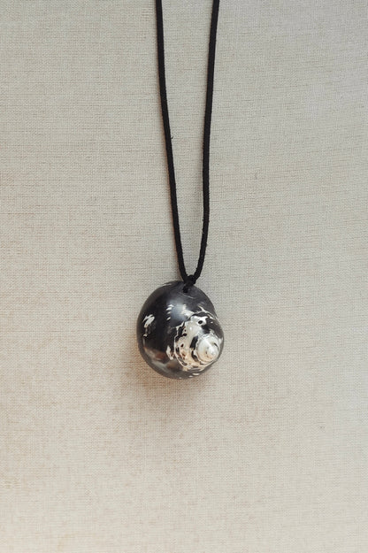 Necklace with a textured silver pendant on a light gray background