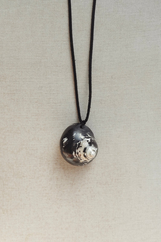 Necklace with a textured silver pendant on a light gray background